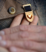 Courageous Love Medal gold heart and shield design with navy ribbon worn as symbolic recognition jewelry