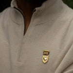 Gold Courageous Love Medal recognition jewelry featuring heart and shield emblem worn on neutral sweater